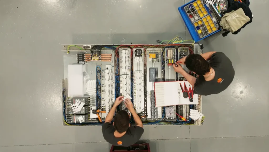 Equipo de electricistas industriales montando cuadros en SISTEIN